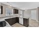 Modern kitchen featuring granite counters, white appliances, dark cabinets, and tiled flooring at 8702 Wood Sorrel Ct, Matthews, NC 28105
