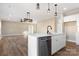 Open kitchen with white cabinets, island, stainless steel appliances, and pendant lighting at 9181 Cherokee Dr, Hickory, NC 28601