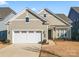 Tan two-story house with white garage door and landscaping at 1025 Lake Como Dr, Monroe, NC 28110