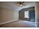 A cozy bedroom features neutral tones, a ceiling fan, a window, and a stylish blue door at 1037 Oakmont Dr, Rock Hill, SC 29732