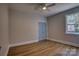 Comfortable bedroom featuring a ceiling fan, wood-look flooring, and a large window at 1037 Oakmont Dr, Rock Hill, SC 29732