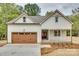 Charming farmhouse exterior with wood-look garage door, covered porch, and manicured landscaping at 1037 Oakmont Dr, Rock Hill, SC 29732