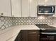 Close-up of kitchen features including white countertops, dark cabinets, tile backsplash, and stainless appliances at 1037 Oakmont Dr, Rock Hill, SC 29732