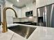 Close up of kitchen island featuring a gold faucet, stainless appliances, and white countertops at 1037 Oakmont Dr, Rock Hill, SC 29732