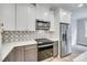 Bright kitchen with stainless steel appliances, white cabinets, tile backsplash, and marble countertops at 1037 Oakmont Dr, Rock Hill, SC 29732