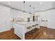 Modern kitchen with white cabinets, granite countertops, and a large island at 116 Cedar Branch Ct, Mooresville, NC 28117