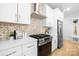 Close-up of kitchen featuring stainless steel appliances, white countertops and cabinets, and decorative backsplash at 1305 39Th Avenue Ne Pl, Hickory, NC 28601