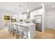 Spacious kitchen island with bar seating, stainless steel refrigerator, modern lighting, and a sliding glass door to the backyard at 1305 39Th Avenue Ne Pl, Hickory, NC 28601