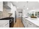 Bright kitchen featuring white cabinets, stainless steel appliances, stylish backsplash, and open layout to dining area at 1305 39Th Avenue Ne Pl, Hickory, NC 28601