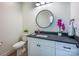 Modern bathroom with a dark vanity, round mirror, and white cabinets at 187 Lone Pine Rd, Statesville, NC 28625