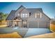 Two-story farmhouse with gray siding, two-car garage, and covered porch at 187 Lone Pine Rd, Statesville, NC 28625