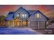 Two-story farmhouse with gray siding, two-car garage, and covered porch at dusk in the snow at 187 Lone Pine Rd, Statesville, NC 28625