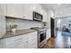 Modern kitchen featuring stainless steel appliances, white cabinets, marble backsplash, and hardwood floors at 2013 Federation Ct, Charlotte, NC 28205