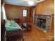 Living room with fireplace, hardwood floors, and wood paneling at 211 Walnut Ave, Mount Holly, NC 28120