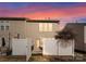 Evening view of townhouse exterior with fenced patio at 2430 Kensington Station Pkwy, Charlotte, NC 28210