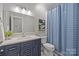 Modern bathroom with dark vanity, white countertop, and a blue shower curtain at 3065 River Bend Dr, Tega Cay, SC 29708