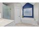 Bathroom with soaking tub, walk-in shower, and a blue accent wall at 3065 River Bend Dr, Tega Cay, SC 29708