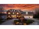 Brick home with a well-manicured lawn, circular driveway, and a three-car garage, illuminated at dusk at 4165 54Th Ne Ave, Hickory, NC 28601