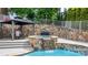A backyard pool features a stone waterfall, spa, and a covered gazebo seating area with outdoor grilling at 4165 54Th Ne Ave, Hickory, NC 28601