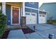 Two-car garage and inviting front entry with a red door at 4418 Huntley Glen Dr, Pineville, NC 28134