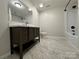 Modern bathroom with dark vanity, white fixtures, and marble-look tile floor at 648 Scotts Creek Rd, Statesville, NC 28625