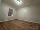 Bright bedroom featuring light walls, wood-look floors, and a window with blinds at 648 Scotts Creek Rd, Statesville, NC 28625