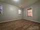 Well-lit bedroom with neutral walls, wood-look floors, and two windows at 648 Scotts Creek Rd, Statesville, NC 28625