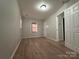 Spacious bedroom with wood-look floors, neutral walls, and an open door to another room at 648 Scotts Creek Rd, Statesville, NC 28625