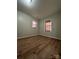 Well-lit bedroom with neutral walls, wood-look floors, and two windows at 648 Scotts Creek Rd, Statesville, NC 28625