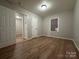 Spacious bedroom with wood-look floors, neutral walls, and an open door to another room at 648 Scotts Creek Rd, Statesville, NC 28625