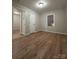 Spacious bedroom with wood-look floors, neutral walls, and an open door to another room at 648 Scotts Creek Rd, Statesville, NC 28625