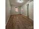 Spacious bedroom with wood-look floors, neutral walls, and an open door to another room at 648 Scotts Creek Rd, Statesville, NC 28625