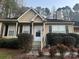 Tan house with white door, landscaping, and black shutters at 9325 Four Mile Creek Rd, Charlotte, NC 28277