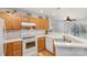 Kitchen featuring wooden cabinets, white appliances, and a view into the dining area at 9325 Four Mile Creek Rd, Charlotte, NC 28277