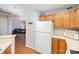 Open kitchen featuring white appliances and wood cabinets with sightlines to the living room at 9325 Four Mile Creek Rd, Charlotte, NC 28277