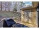 Patio with grill, storage shed, and wooded backdrop at 9325 Four Mile Creek Rd, Charlotte, NC 28277