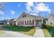 Charming yellow house with maroon shutters, welcoming porch, and manicured lawn at 10117 Bishops Gate Blvd, Pineville, NC 28134