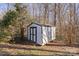 White shed with black trim in wooded backyard at 1013 Ashwood Pl, Salisbury, NC 28146