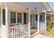 Front porch with white railing and red chairs at 102 Hickory St, Locust, NC 28097