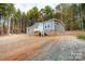 Gray mobile home on a gravel driveway with wooded backdrop at 114 River Ridge Ln, Hickory, NC 28601