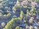 Aerial view of a house nestled amongst lush green trees at 121 Sierra Woods Dr, Troutman, NC 28166