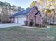 Brick three-car garage with a paved driveway at 121 Sierra Woods Dr, Troutman, NC 28166