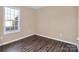 Simple bedroom with wood-look floors and a window at 13502 Tartarian Ct, Charlotte, NC 28215