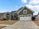 Beautiful home with gray siding, stone accents, and a large driveway at 1410 Tranquility Blvd, Lancaster, SC 29720