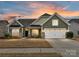 Two-story house with green siding, stone accents, and a two-car garage at 1410 Tranquility Blvd, Lancaster, SC 29720