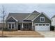 Craftsman style home with green siding, stone accents, and a two-car garage at 1410 Tranquility Blvd, Lancaster, SC 29720