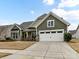 Two-story house with green siding, stone accents, and a two-car garage at 1410 Tranquility Blvd, Lancaster, SC 29720