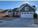 Two-story house with green siding, stone accents, and a two-car garage at 1410 Tranquility Blvd, Lancaster, SC 29720