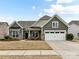 Green-sided two-story house with a two-car garage and manicured lawn at 1410 Tranquility Blvd, Lancaster, SC 29720