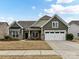 Two-story house with green siding, stone accents, and two-car garage at 1410 Tranquility Blvd, Lancaster, SC 29720